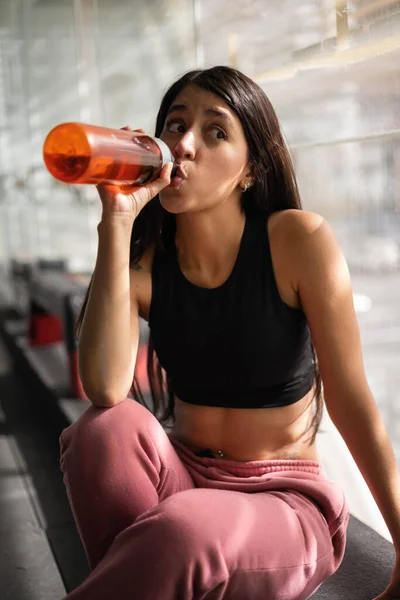 与水一起喝水的健康女人穿着运动服 做运动 进行体育锻炼 从瓶子里喝水 — 图库照片