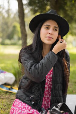 Güzel kadın manken desenli elbise, süveter ve şapka giyer. Moda ve güzellik. Güneş ışığında gülümseyen kadın yaşam tarzı.