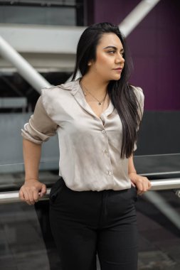 Genç bir insanın resmi giysilerini şehirde yönetici, Latin bir kadın olarak giymesi, güzellik ve gençlik modası, günışığı, trendler