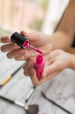 Elinde pembe ruj, fırça, kişisel ve profesyonel aksesuar, göz kamaştırıcı makyaj, yaşam tarzı ve güzellik var.