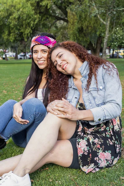 day in the park, romantic activity and lifestyle, lgbti community, rest and leisure of couple of young women with curly straight hair, beauty and fashion