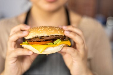 Peynirli, etli ve sebzeli nefis bir hamburgerin dokusunun detayları, sağlıksız yemekler, menü için stüdyo fotoğrafı, fast food restoranı, arka plan.