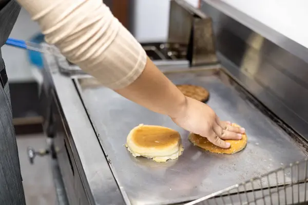 heating hamburger bun on a grill, food preparation, chef workplace, unhealthy ingredients, kitchen details