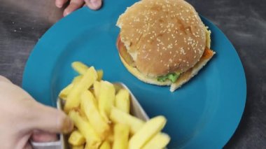 Hamburger ve patates kızartmasıyla süsleme tabağı, hızlı ve sağlıksız restoran yemekleri, teslimat ve yemek hazırlama duvar kağıdı.