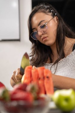 Genç kadın tropikal meyvelerle kahvaltı hazırlıyor, vitaminli sağlıklı atıştırmalıklar, çilekli diyet, karpuz, üzüm, ev işi ile yaşam tarzı