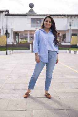 Çekici bir kadın manken gündelik ve genç bir kıyafet giyiyor, güneşli bir şehirde poz veriyor, yaşam tarzı ve moda, doğal güzelliği olan Latin bir kadının portresi