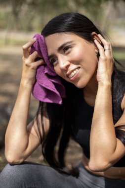 Saçı düz genç bir kadının spor rutini. Terini, sağlıklı yaşam tarzını ve sağlığını kurutmak için havlu kullanıyor. Spor.