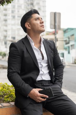 Modern, kısa saçlı, resmi iş kıyafetleri giyen, şehirde yaşam tarzı ve güzelliği olan çekici bir genç adam.