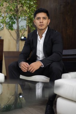 Kısa saçlı, takım elbiseli, şehirde yaşam tarzı ve güzelliği olan genç Latin bir adama yakın durun.