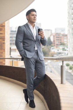 Gri takım elbiseli, şehirde yaşam tarzı olan, iş gününde mola veren, bir insanın portresini çizen genç bir adam.