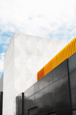 Canlı kırmızı ve turuncu tasarımlı minimalist bir duvar. Kalın renkler çarpıcı bir görsel karşıtlık yaratarak uzaya enerji ve modern yetenek katıyor.,