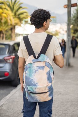 A young boy seen from behind, wearing an animal-themed backpack. Ideal for themes of youth, fashion, travel, and animal love. clipart