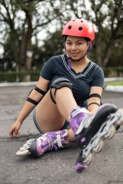 Genç, güzel bir kız kaldırımın kenarında oturuyor, paten yapmaya ara veriyor, dışarıda dinleniyor..