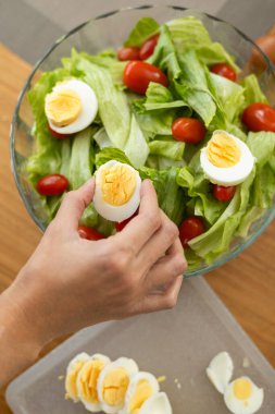 Bir bardak süt ve tam buğday ekmeğiyle tamamlanmış domates, marul ve haşlanmış yumurta içeren güzel düzenlenmiş bir salata..