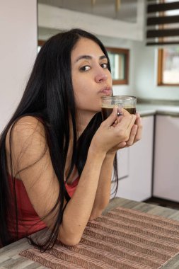 Bir kadın uyanır uyanmaz sıcak bir fincan kahvenin keyfini çıkarır. Sabahın erken saatlerinde huzur dolu, rahat mutfağında kucaklaşır..