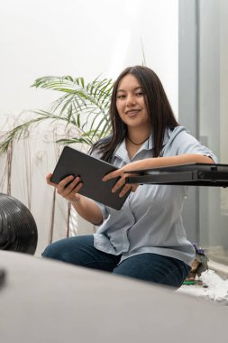 Kendinden emin bir şekilde oturan bir girişimci tablet üzerinde sunum güvertesinden geçer. Çağdaş ve minimal alan yatırımcılarla görüşmeye hazırlanırken odak noktası ve girişimci ruhuyla örtüşüyor.