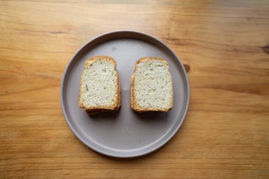 Temiz beyaz bir tabakta iki kızarmış ekmek diliminin yakın çekimi. Doku ve renk güne mükemmel bir başlangıç, yemek blogları ve kahvaltı menüleri için ideal..