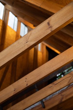 Bir dizi açılı ince ahşap kiriş, glamping kulübesinde rafine bir çatı yapısı oluşturuyor. Tasarım simetriyi, doğal maddeleri ve minimalist orman estetiğini vurguluyor..