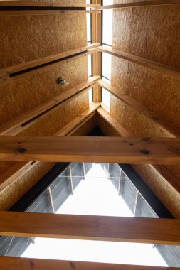 İçeriden görülen ahşap çatı manzarası, kırsal kirişler ve sıcak tonlarda sergileniyor. Mimarlık, kabinler ve doğal tasarım temaları için ideal.