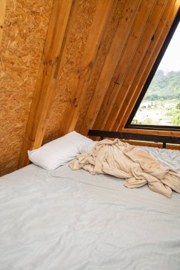 Yumuşak, buruşuk çarşafları olan boş bir yatak sıcak, kırsal bir çadır içinde, rahatlatıcı sabahlar çağrıştırıyor ve doğada huzur uyandırıyor..