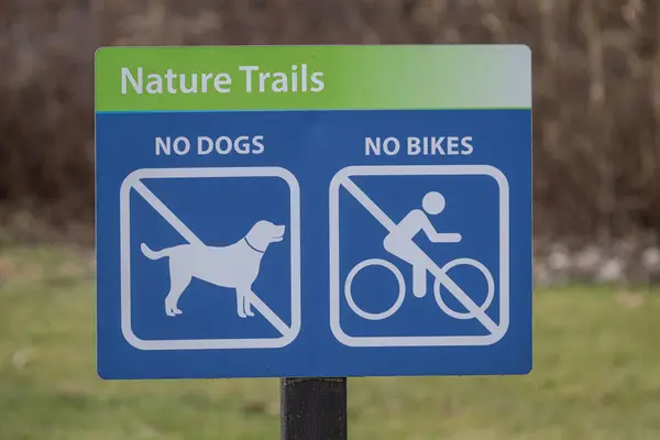mounted sign prohibits bikes and dogs from being on the nature trails in a public park