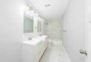 Konut banyosu modern donanımlar ve profesyonel yenilemeyi gösteren yeni bir kibir ve ışıklandırma ile güncellendi.