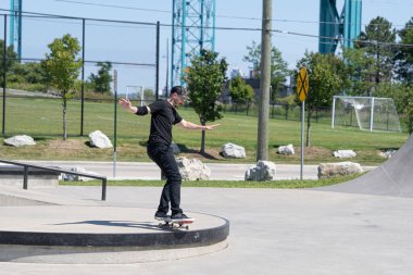 Patenciler ve motorcular numaralarını güneşli bir yaz gününde halka açık olan açık bir kaykay parkında yapıyorlar.