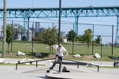 Patenciler ve motorcular numaralarını güneşli bir yaz gününde halka açık olan açık bir kaykay parkında yapıyorlar.