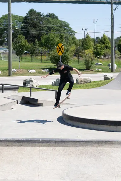 Patenciler ve motorcular numaralarını güneşli bir yaz gününde halka açık olan açık bir kaykay parkında yapıyorlar.