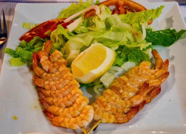 Cadiz 'de bir barda, salata ve limon soslu ızgara karides şiş tabağı.).