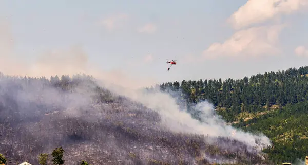 İtfaiye helikopteri su yükünü boşaltmak üzere.