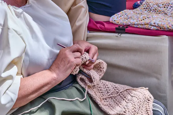 Woman knitting with handmade wool yarn