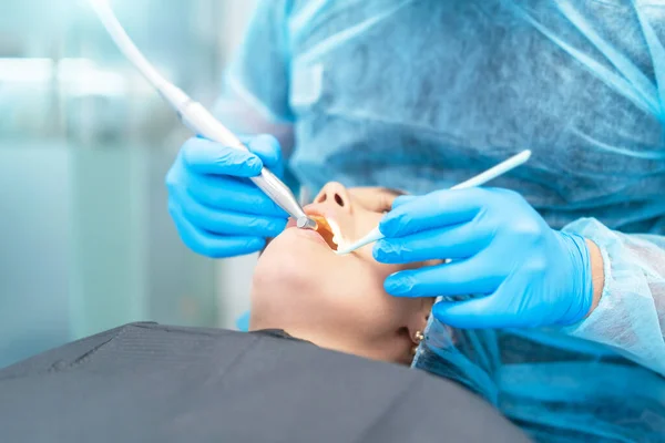 口腔治療を提供する歯科椅子の女性患者と男性歯科医 — ストック写真