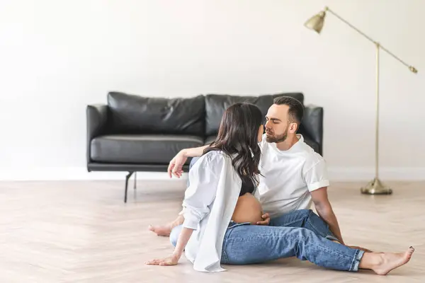 남자와 여자는 방에서 소파에 바닥에 앉아있다 스톡 사진