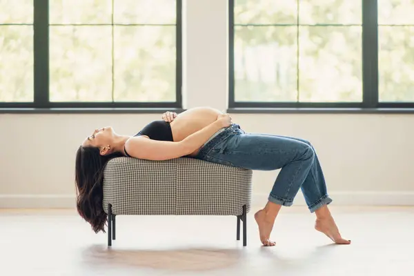 一个女人躺在房间里的沙发上 既放松又舒服 免版税图库照片