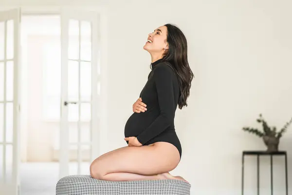 의자 위에 앉아 임신 한 여자. 스톡 사진