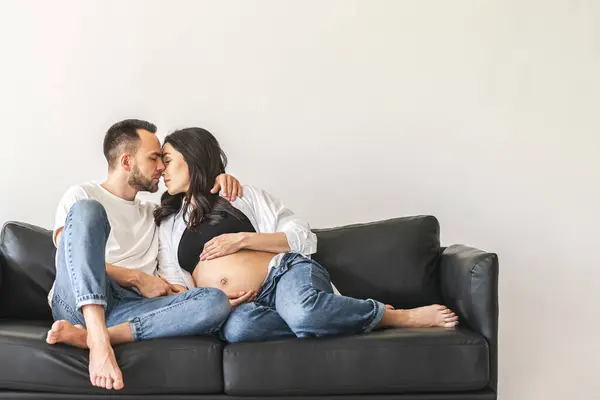 一个男人和一个女人坐在沙发上 亲切地拥抱在一起 分享片刻亲密的时光 图库图片