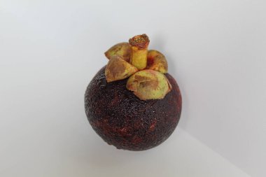 Beyaz arka planda izole edilmiş bir mangosteen meyvesi.
