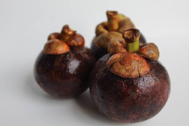 Üç mangosteens meyve izole beyaz zemin üzerine