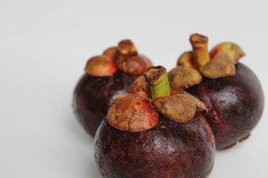 Üç mangosteens meyve izole beyaz zemin üzerine