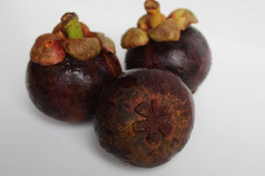 Üç mangosteens meyve izole beyaz zemin üzerine