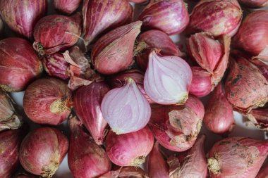 Beyaz zemin üzerinde soyulmamış kırmızı arpacık soğanı, düz uzanmış