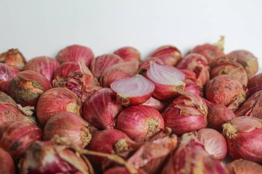 Beyaz arkaplanda soyulmamış kırmızı arpacık soğanı