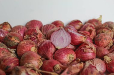 Beyaz arkaplanda soyulmamış kırmızı arpacık soğanı