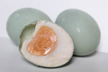 Yarım tuzlu yumurta, beyaz arka planda izole edilmiş.