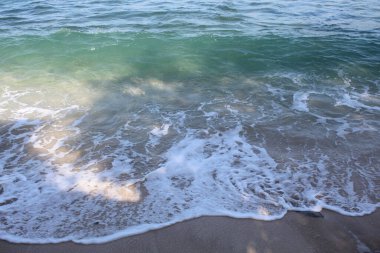 Boş kumsal. Açık deniz suyu, deniz dalgaları, deniz köpüğü ve beyaz kum.