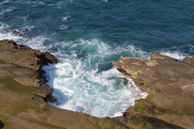 Deniz dalgası kırılır ve deniz köpüğü oluşturur. Pacitan, Endonezya 'daki Klayar Sahili manzarası