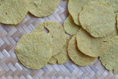 Kerupuk Nasi, Kerupuk Gendar or Rice Crackers, before fried. Food from Indonesia. Round shape. On a woven bamboo tray clipart