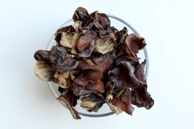 Kurutulmuş jöle kulağı, ya da ahşap kulak mantarı, ya da siyah mantar, ya da şeffaf kâse içinde Auricularia auricula judae. Beyaz arka planda izole edilmiş. Düz ya da üst görünüm