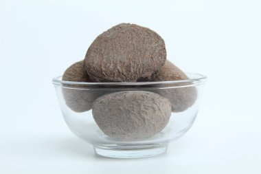 Endonezya mutfağında baharat olarak kullanılan kurutulmuş Pangium edule tohumu yiyeceği daha koyu ya da siyah yapar. Beyaz arkaplanda izole.